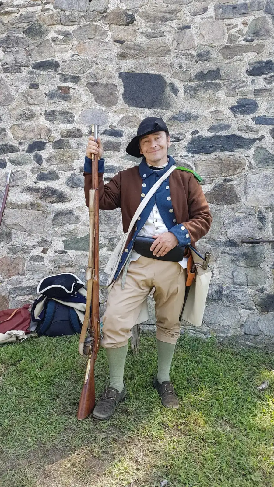 Revolutionary soldier with musket by a stone wall